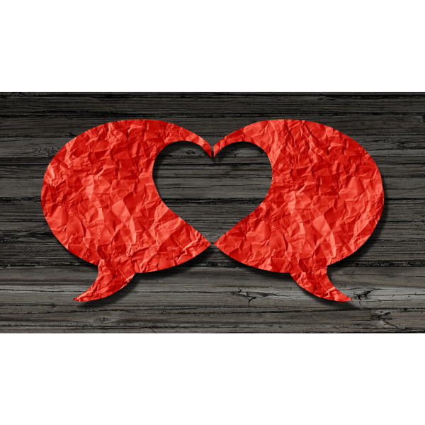Two red speech bubbles form a heart on a table